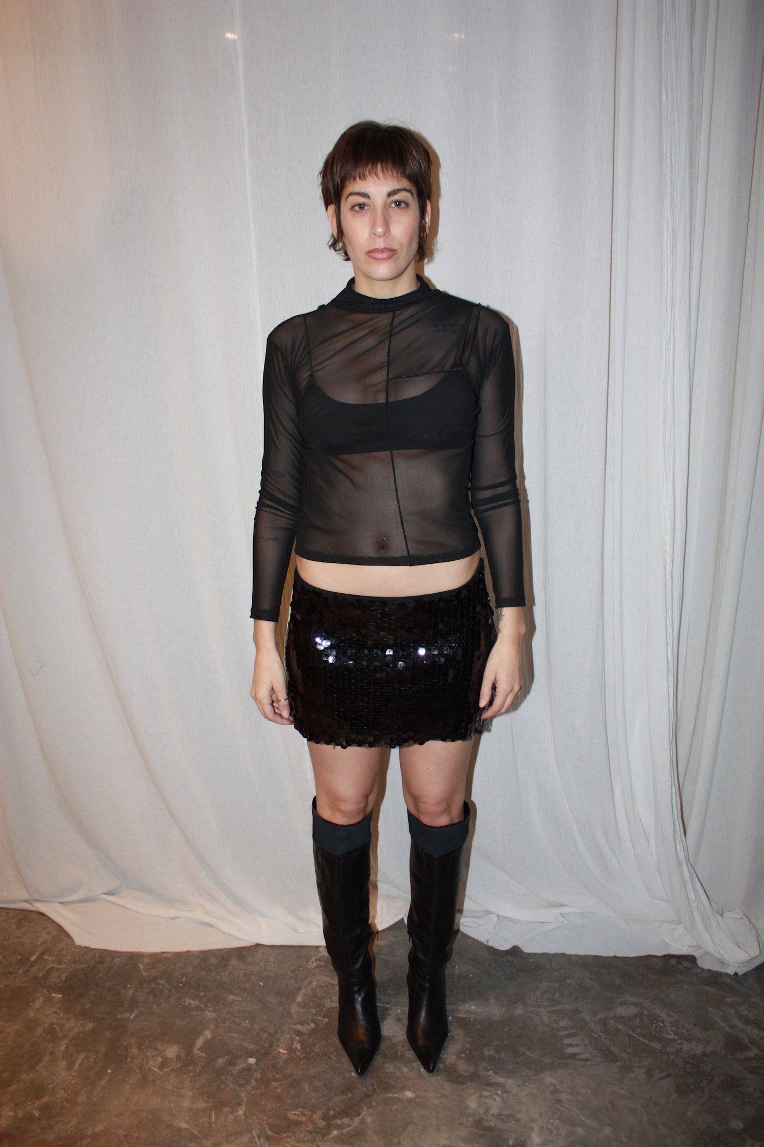 Long sleeve black mesh top. The top is sheer with a high neckline and a cropped hem.
