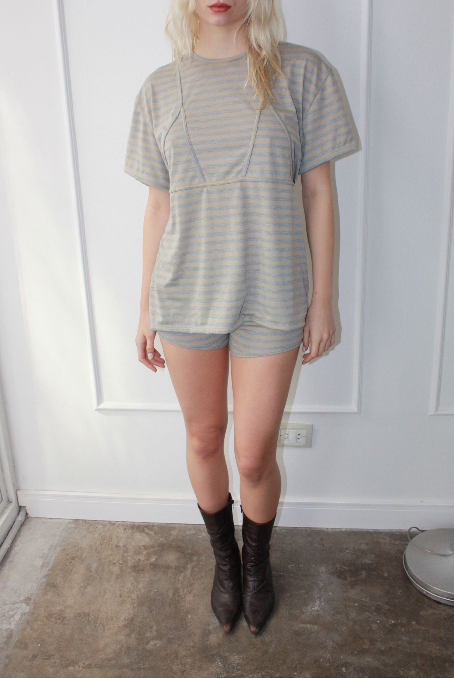 Model wearing a striped blue and beige oversized tee.